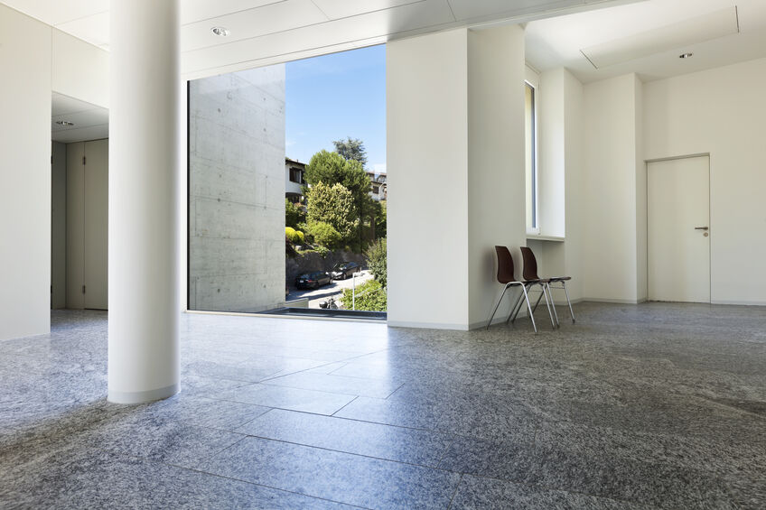 Granite floors stand out against white, neutral-toned walls in an office building.